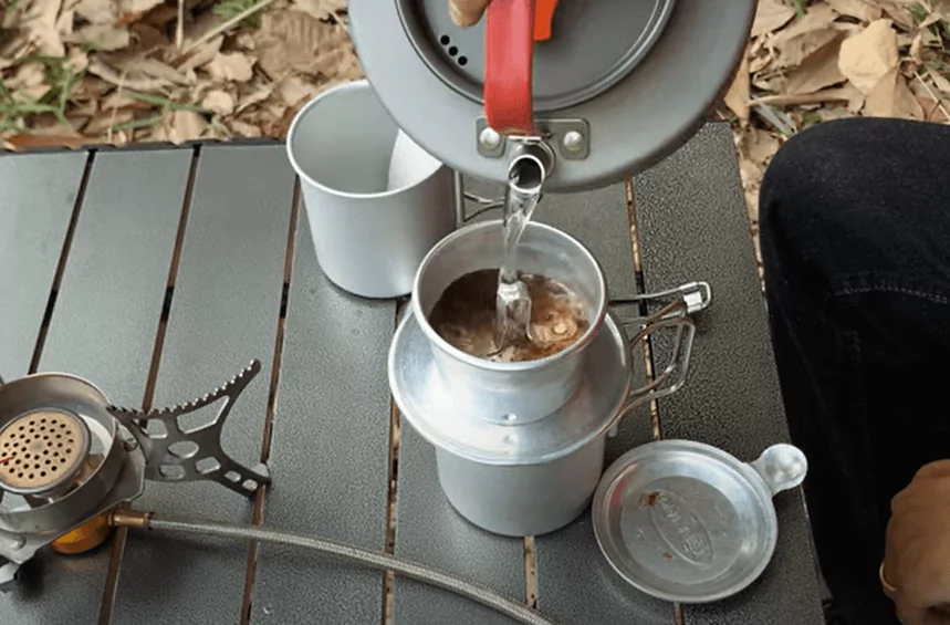 adding water in vitnamese phin coffee brewing on a camp