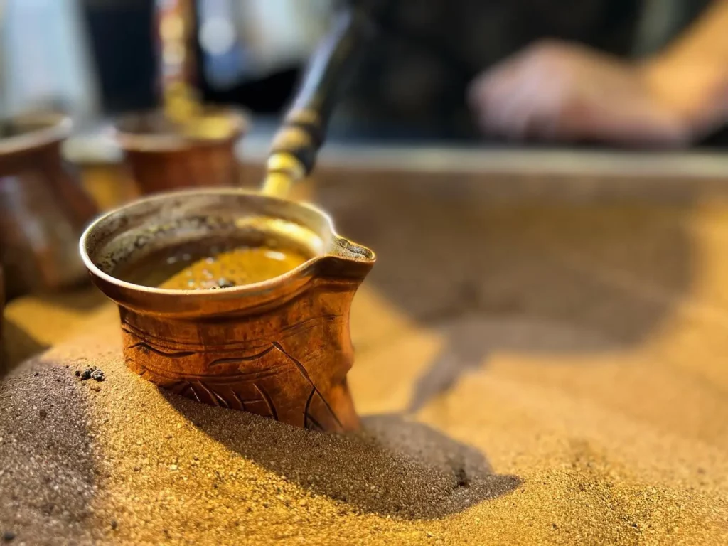 Turkish` coffee boiling on hot sand