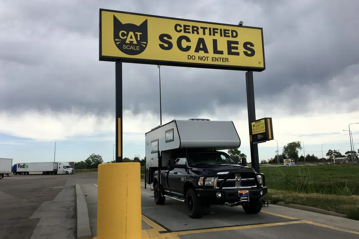Best Lightweight Truck Campers (2026): 15 Picks That Won't Overload Your Truck 7 Truck with a slide-in camper loaded on a CAT scale at a truck stop