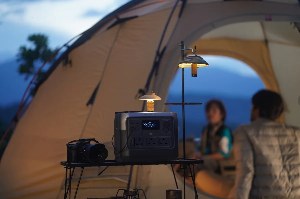 EcoFlow power station powering LED string lights at a tent campsite at dusk