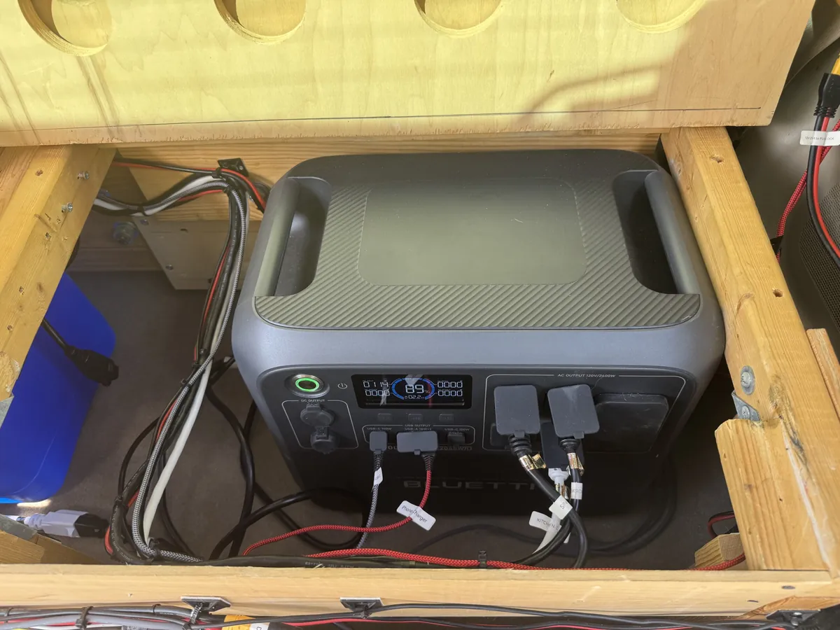 Bluetti power station secured and wired inside a camper rear storage compartment