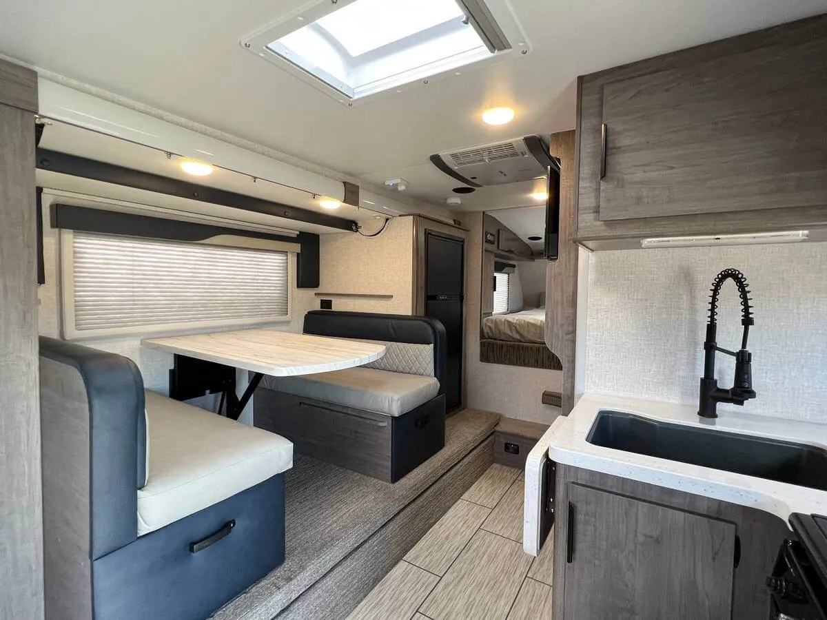 Best Truck Camper for Full-Time Living in 2026: 7 Rigs Compared 3 Interior of a Lance 1172 double-slide truck camper living area with dinette, kitchen sink, skylight and residential-style cabinets
