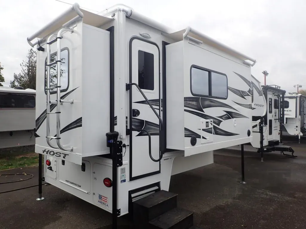 Best Truck Camper for Full-Time Living in 2026: 7 Rigs Compared 4 Host Mammoth triple-slide truck camper with side entry door open and steps down