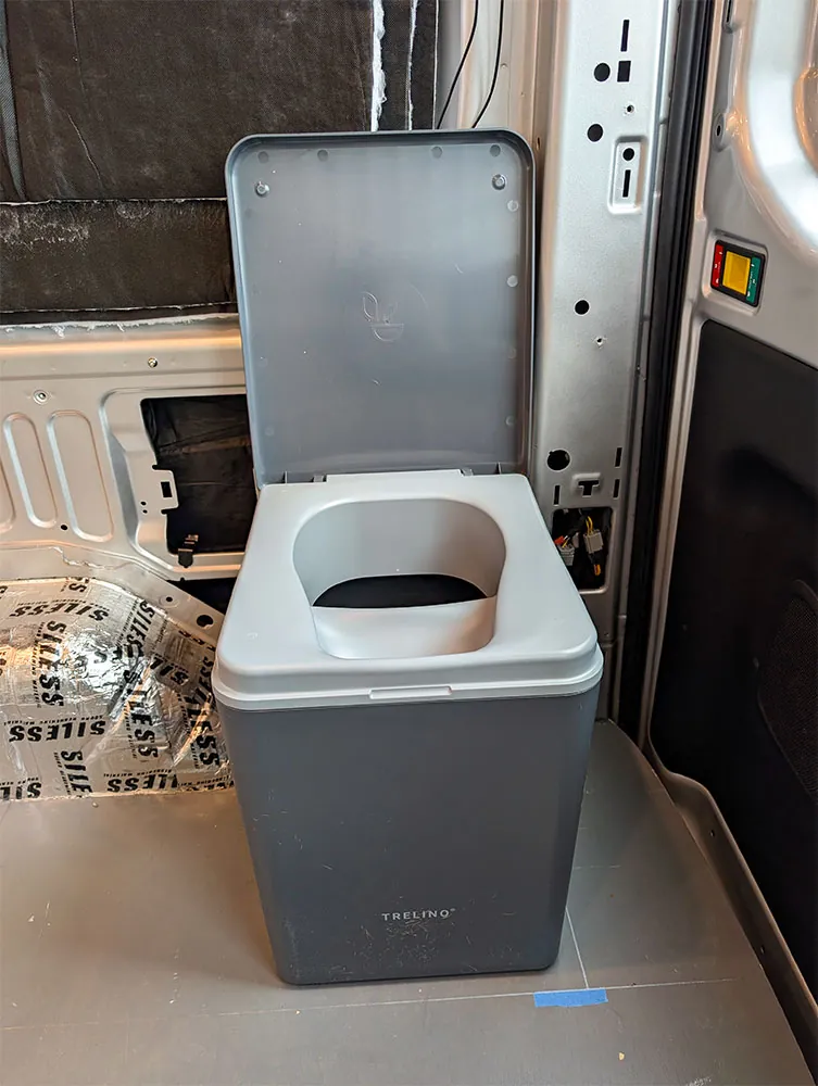 Trelino urine-diverting composting toilet with the lid open inside a camper, no plumbing