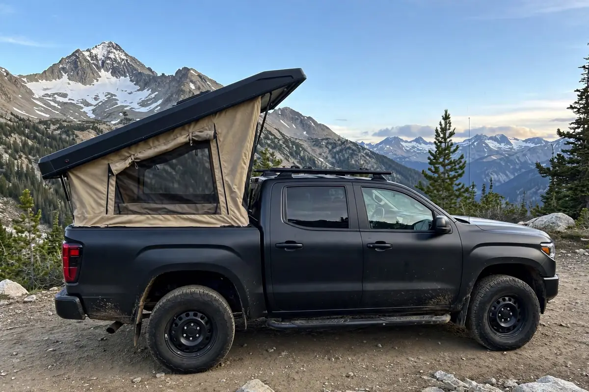 Best Truck Camper for Toyota Tacoma: What Actually Fits Without Overloading It 5 Wedge camper popped open on a Toyota Tacoma with mountain peaks behind