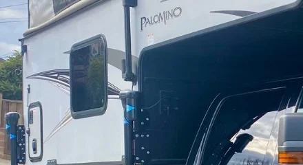 Budget Truck Campers Under $15,000: What I Found in 2026 3 Close-up of the Palomino brand badge decal on the siding of a used truck camper