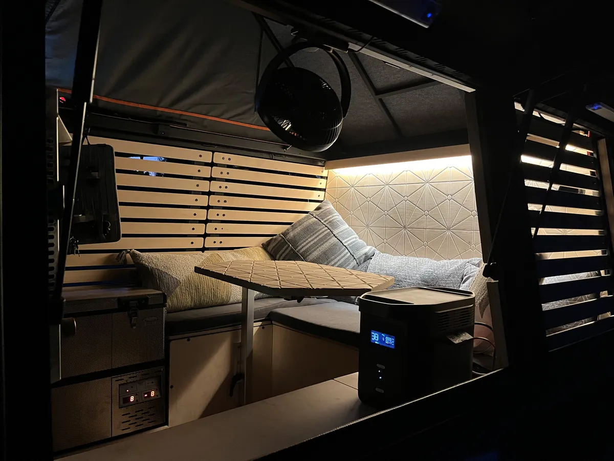 Budget Truck Campers Under $15,000: What I Found in 2026 8 Cozy truck camper interior at night with warm lighting and a dinette
