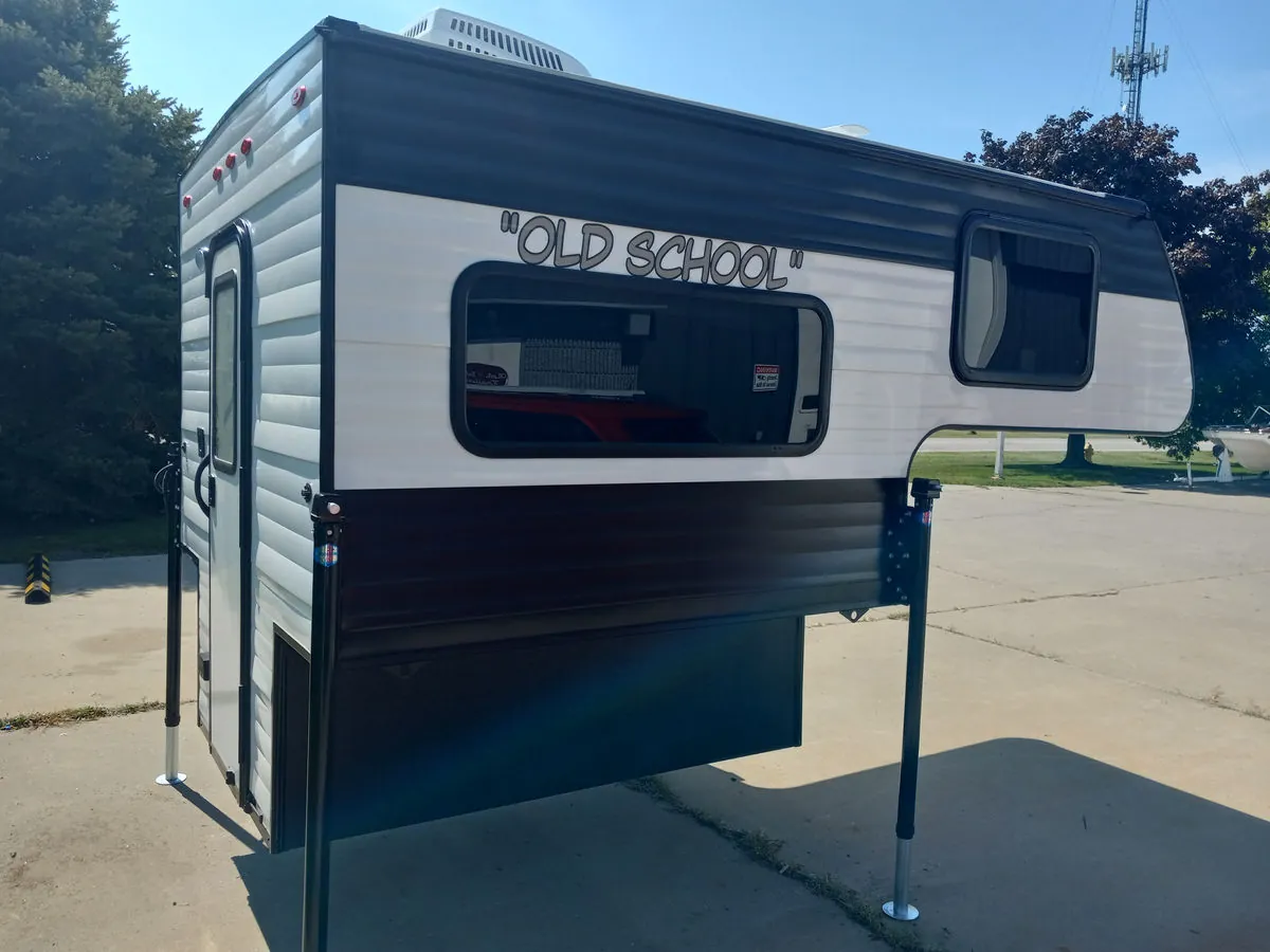 Budget Truck Campers Under $15,000: What I Found in 2026 7 New Old School factory-direct aluminum truck camper on jacks at the factory lot