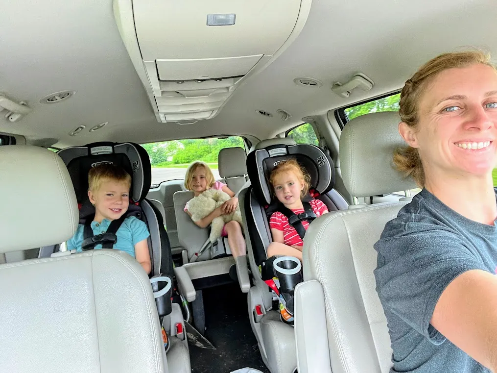 Can You Ride in a Truck Camper? The 2026 State-by-State Guide 7 Family loading children into belted back seats of a crew-cab truck