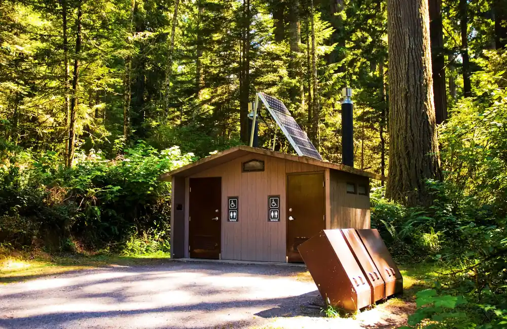 Cassette Toilets for Truck Camper Boondocking: The Complete Honest Guide 7 Campground restroom building in a forest clearing at dawn