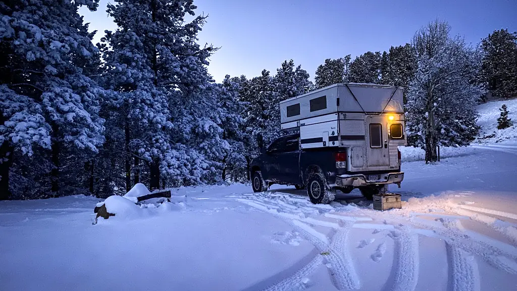 Cassette Toilets for Truck Camper Boondocking: The Complete Honest Guide 6 Truck camper with pop-up roof camping in heavy snow at dusk with warm light in the windows