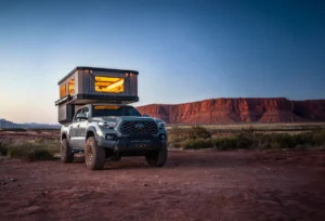 Tune M1 pop-up truck camper fully deployed on a Toyota Tacoma at a desert campsite at dusk