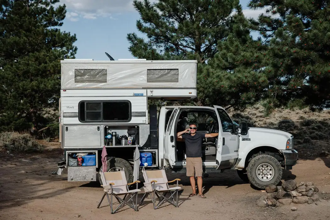 Four Wheel Camper Fleet vs Swift vs Hawk: Which Pop-Up Fits Your Truck? 4 Four Wheel Camper Hawk pop-up truck camper with the roof popped up on a full-size Ford truck at a mountain campsite