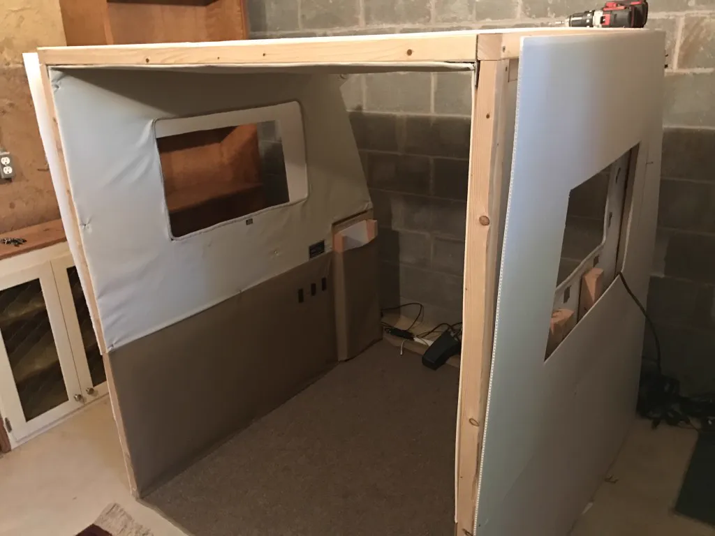 Canvas drop-cloth skin applied over a plywood camper shell in a garage during a Poor Man's Fiberglass build.