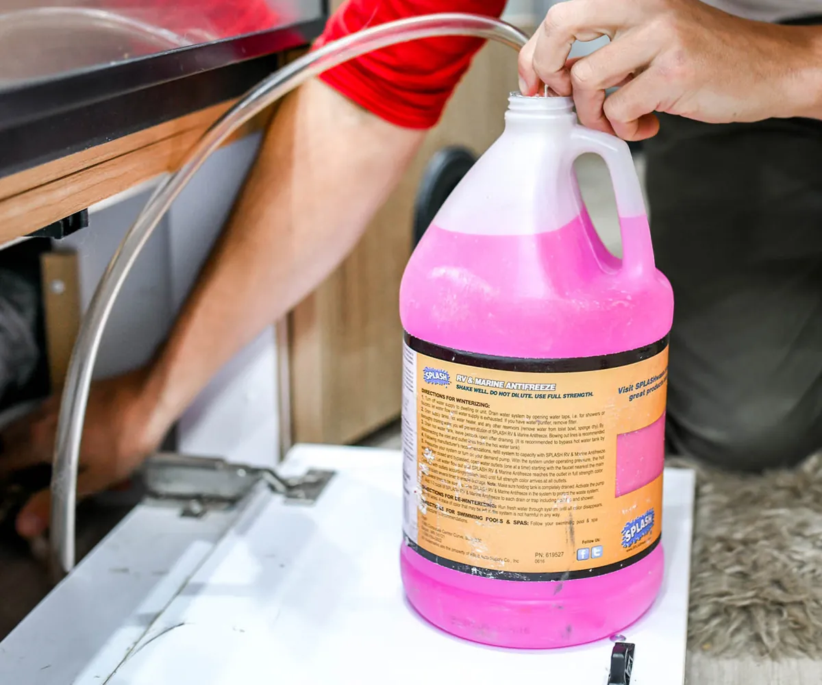 How to Winterize a Truck Camper (2026 Step-by-Step Guide) 2 Pink non-toxic RV antifreeze jugs for winterizing