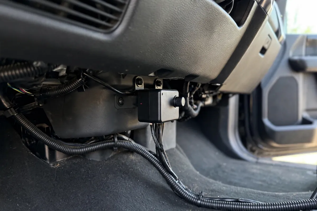 Trailer brake controller mounted under a pickup truck dashboard with its wiring