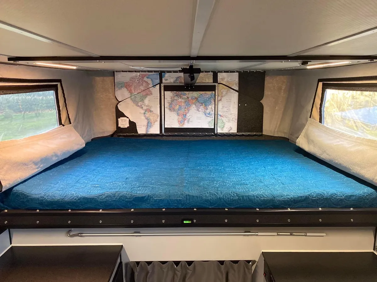 Truck Camper for Tall People: What Actually Works at 6'2" and Up 5 Cabover bed inside a pop-up truck camper showing the full sleeping platform