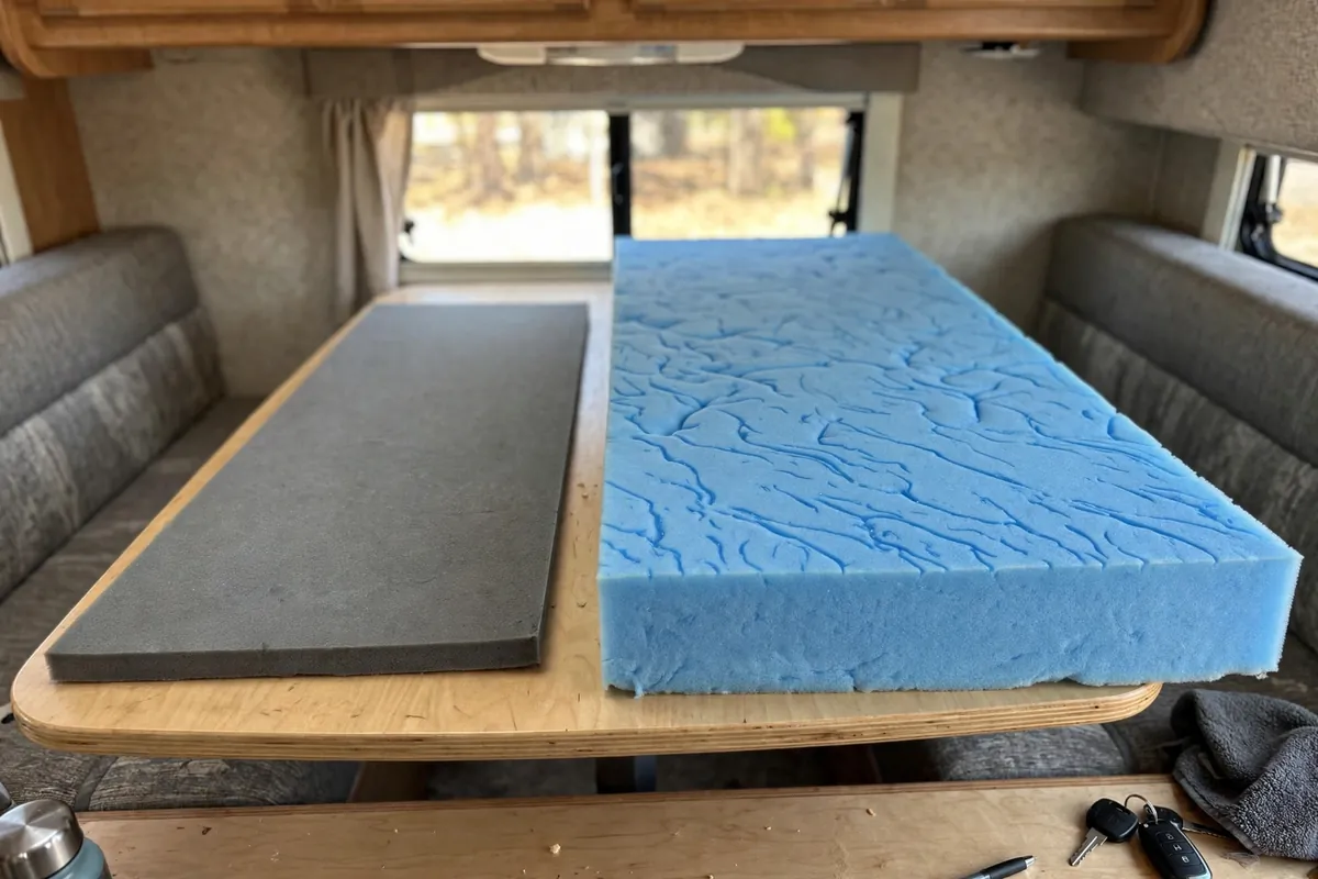 Truck Camper Mattress Upgrade - Fixing the Cabover Sleep Problem 6 Thin factory truck camper foam pad beside a thick gel memory foam topper on a dinette table