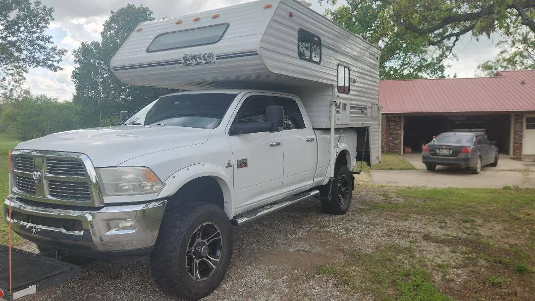 Truck Camper Payload Calculator: How to Know If Your Truck Can Carry Your Camper 4 White Ram 3500 one-ton pickup carrying a hard-side Lance slide-in truck camper, sitting level