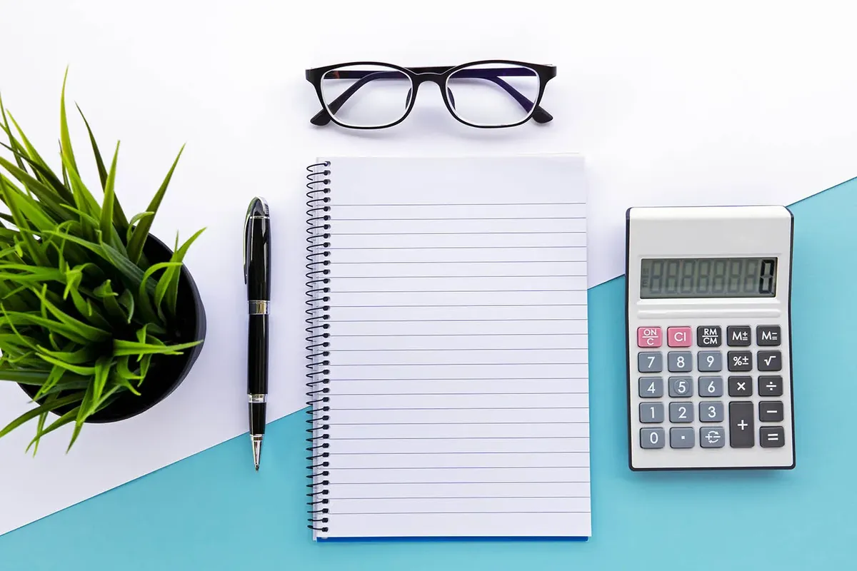 Truck Camper Payload Calculator: How to Know If Your Truck Can Carry Your Camper 3 Overhead view of a notepad worksheet, pen, and calculator ready for payload math