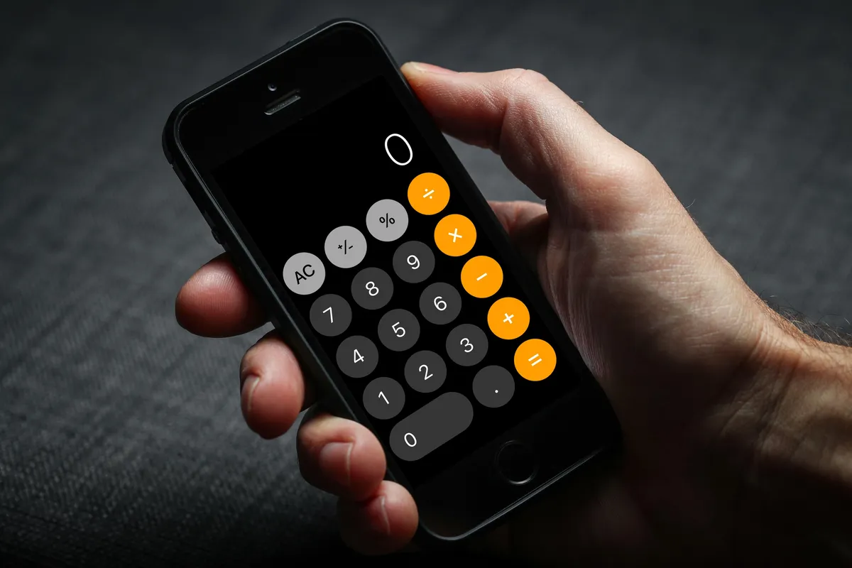 Truck Camper Payload Calculator: How to Know If Your Truck Can Carry Your Camper 7 Hand holding a smartphone showing a calculator app screen for entering payload numbers