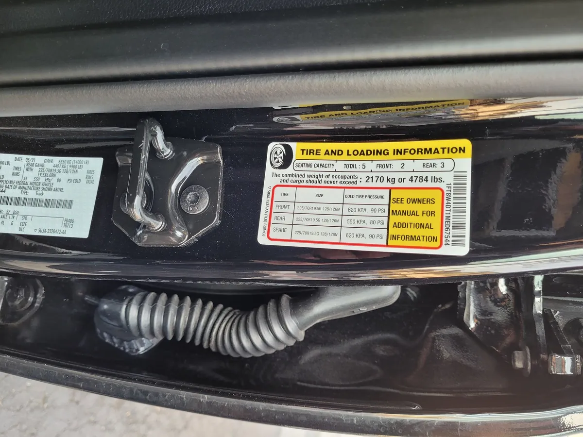Truck Camper Payload Calculator: How to Know If Your Truck Can Carry Your Camper 2 Close-up of a truck's Tire and Loading Information door-jamb sticker showing the "combined weight of occupants and cargo should never exceed" payload line