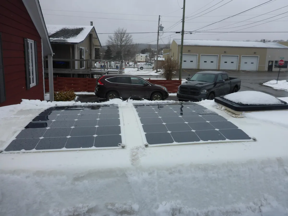 Truck Camper Solar Panels & Lithium Sizing Guide — How Big a System Do You Actually Need? 7 Snow-dusted solar panels on a camper roof in winter