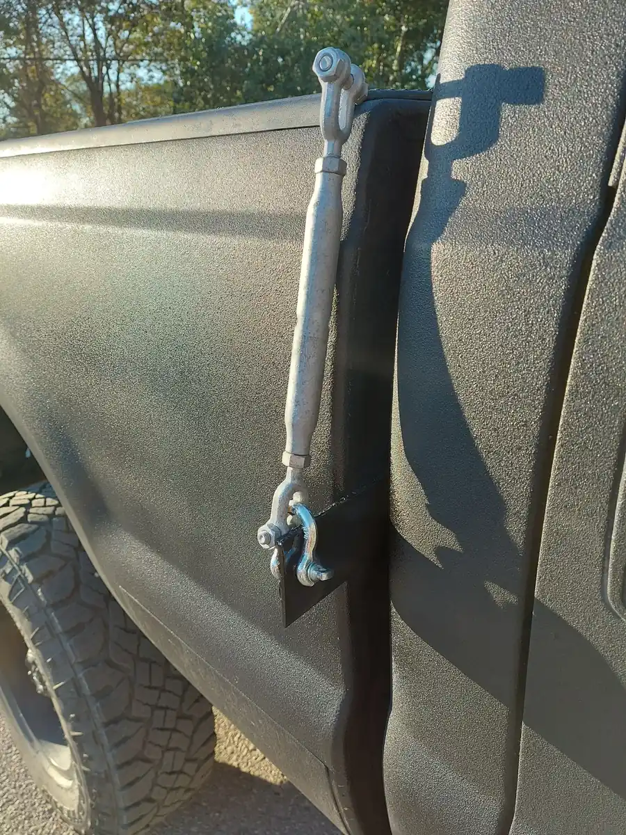 Truck Camper Theft Prevention: A Security Guide That Actually Works 4 Close-up of a turnbuckle tie-down connecting a truck bed rail to a camper anchor point
