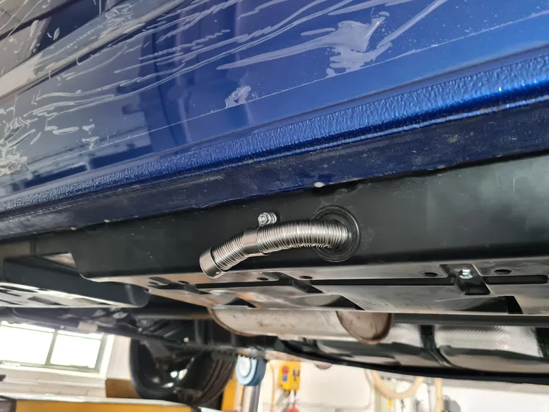 Unbiased Winter Heating Guide: Truck Camper Heater — Diesel vs Propane vs Electric 6 Diesel heater exhaust pipe and combustion air routed through a camper floor, muffler visible